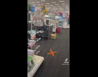 Man sitting on chair at register signs he needs help