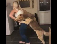 Blonde girl walks through kitchen with her dog holding onto her back