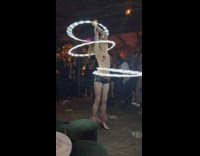 Woman dances with hula hoops at club 