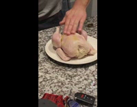 Guy rubs oil on raw chicken prep for cooking 