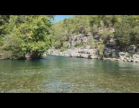 Speedboat full of people drifts and splashes water towards filmer