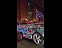 Collab WINY - Man drives convertible car with graffiti design 