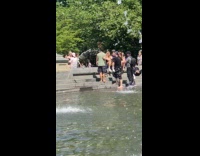 Group filming music video on fountain