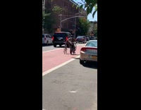 Man rides bike and holds two other bikes on handlebar and on side 