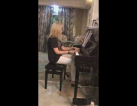 Brown kitten sits on piano music shelf 