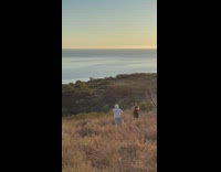 Guy poses with arm flexed beach sunset 