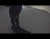 Men Slide Down Snow Slope at Night