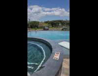 Woman in bikini poses at the pool near the parking lot