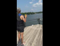 Guy catches football while on jet ski