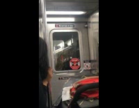 Woman smokes cigarette in between cars on moving subway train