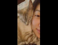 Cat sleeps next to girls face 