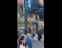 Man hang leg raise on pedestrian stoplight