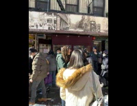 Lion dancers stand on sidewalk 