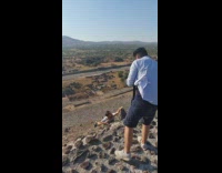 White shirt pyramid hangs off rock 