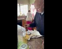 Elderly man putting too much salt on burger 