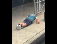 Man doing push ups on sidewalk 