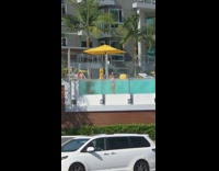 Guy bends in pool bikini girl glass