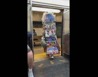 Train passenger exits in big wig and quilt dress 
