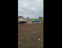 A man breaks paint bottle with brick