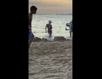 Woman in blue bikini and a cap tiktok dance at the beach