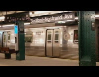 Construction worker stands on the side of subway tracks and train goes by