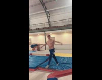 Guy runs down gymnastics track, does flip and lands on yellow safety mat