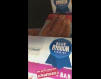 Guy takes ice cream box from the back of the shelf, strawberry shortcake bars