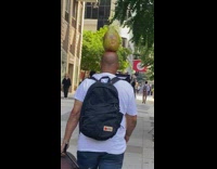 Man balance coconut on head walk street