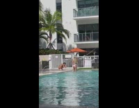 Woman white bikini beside pool orange umbrella