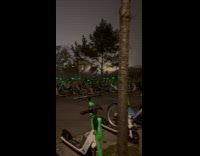 Green lights glow on parked rental scooters