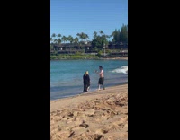 Woman in beach dress walks and vlogs at the beach