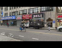 Guy standing on top of bicycle balancing pineapple