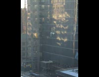 Two portapotties being lowered from skyscraper in construction