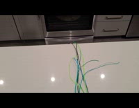 Cat pulls nylon strings from counter 