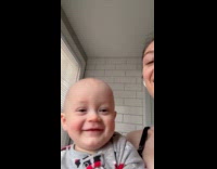 Baby laughs over bubbles from mom gum