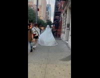 Collab WINY - Person covered white sheet walk on street