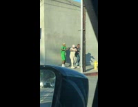 Three men dance beside wall green shirt