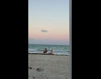 Woman black bikini both feet up beach