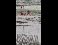 2 women in red dress dance on beach 