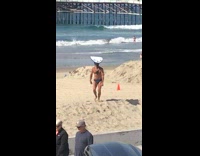 Collab Kook Of The Day - guy in blue speedo balancing surfboard at beach