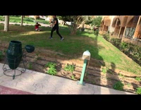 Guy jumps and front flips off second story balcony, lands on shoulder and walks it off