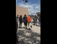 Girl wearing orange safety vest dances outside