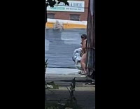 Lady washing her vaginal area on a sidewalk 