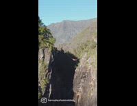 Guy lays in hammock over waterfall 