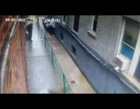 Man pooping in between two buildings outside