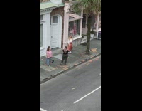 Woman in shiny skirt poses on the sidewalk