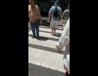 Man walks barefoot across crosswalk