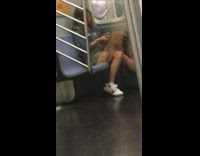 Woman brushes and braids mannequins hair on subway train talks on phone