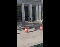 Woman in black suit poses in front of the columns of a building