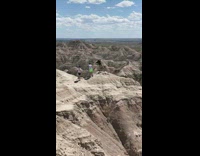 Guy balances one foot brown mountain top 
